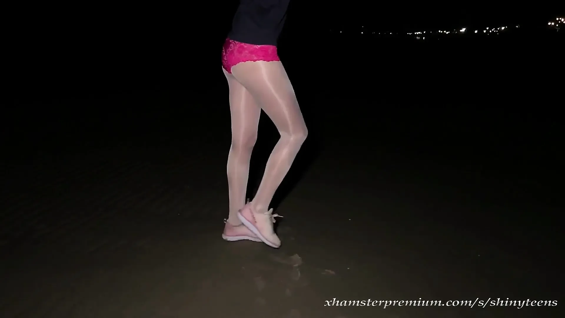 Anna in white shiny pantyhose on the night beach